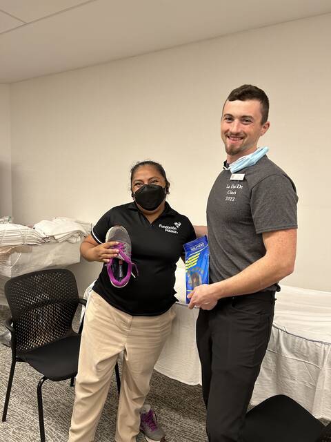 <p>UC Clermont PTA student Jesse Anderson provides shoe orthotics to a patient who spends most of her day on her feet.</p>
